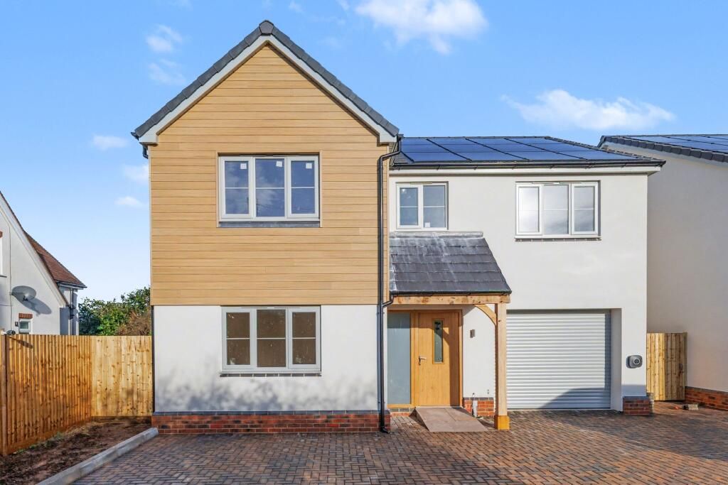 A house with timber cladding over white render