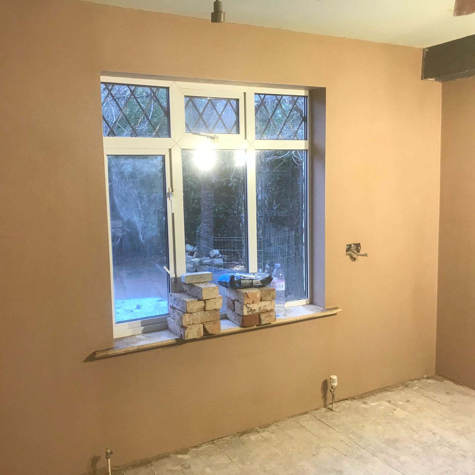 A wall boarded in Thermaline Plus and replastered round a leaded window in Badsey
