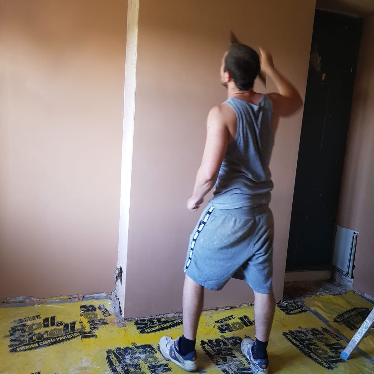 Ryan skimming a wall in a cottage in Hampton