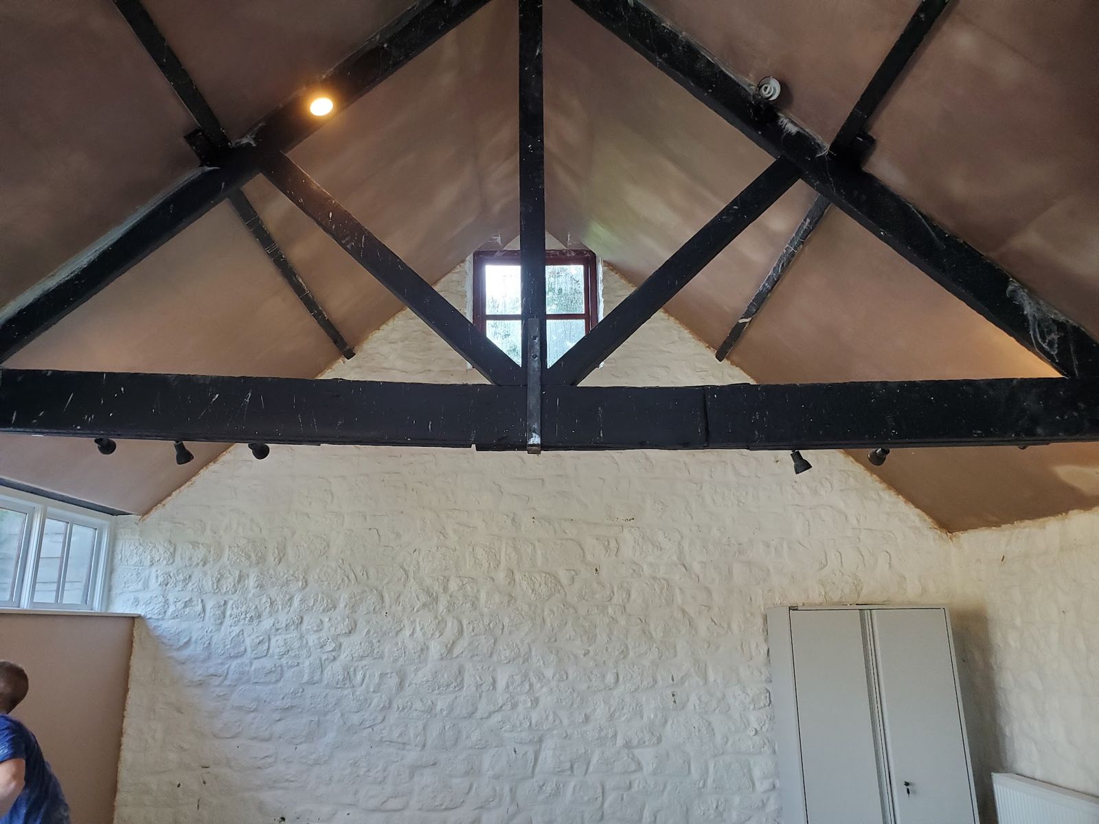 A vaulted room with black beams, the ceiling between them freshly plastered