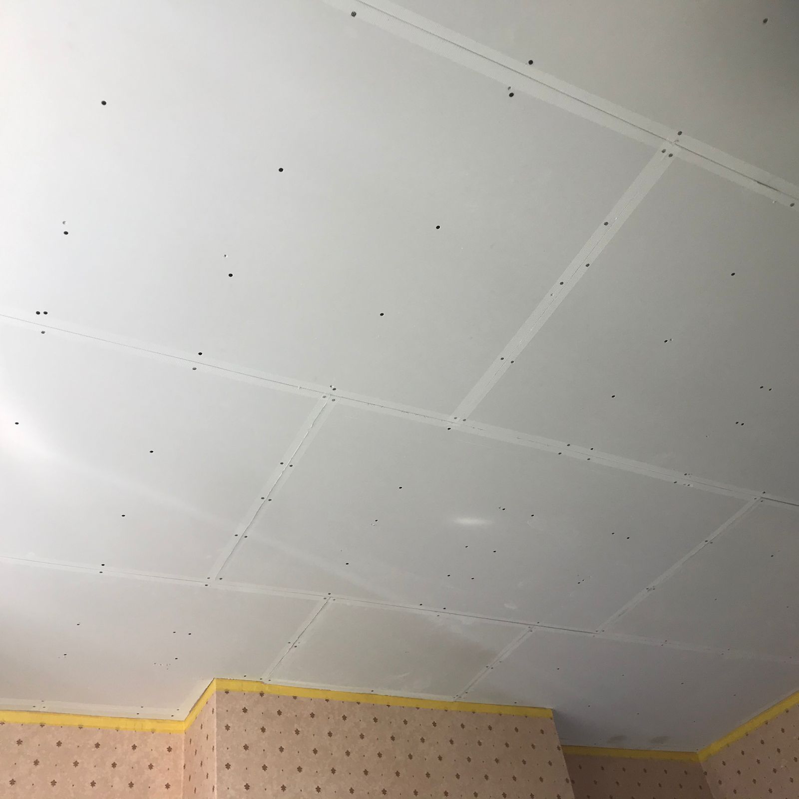 A ceiling overboarded with plasterboard before skimming