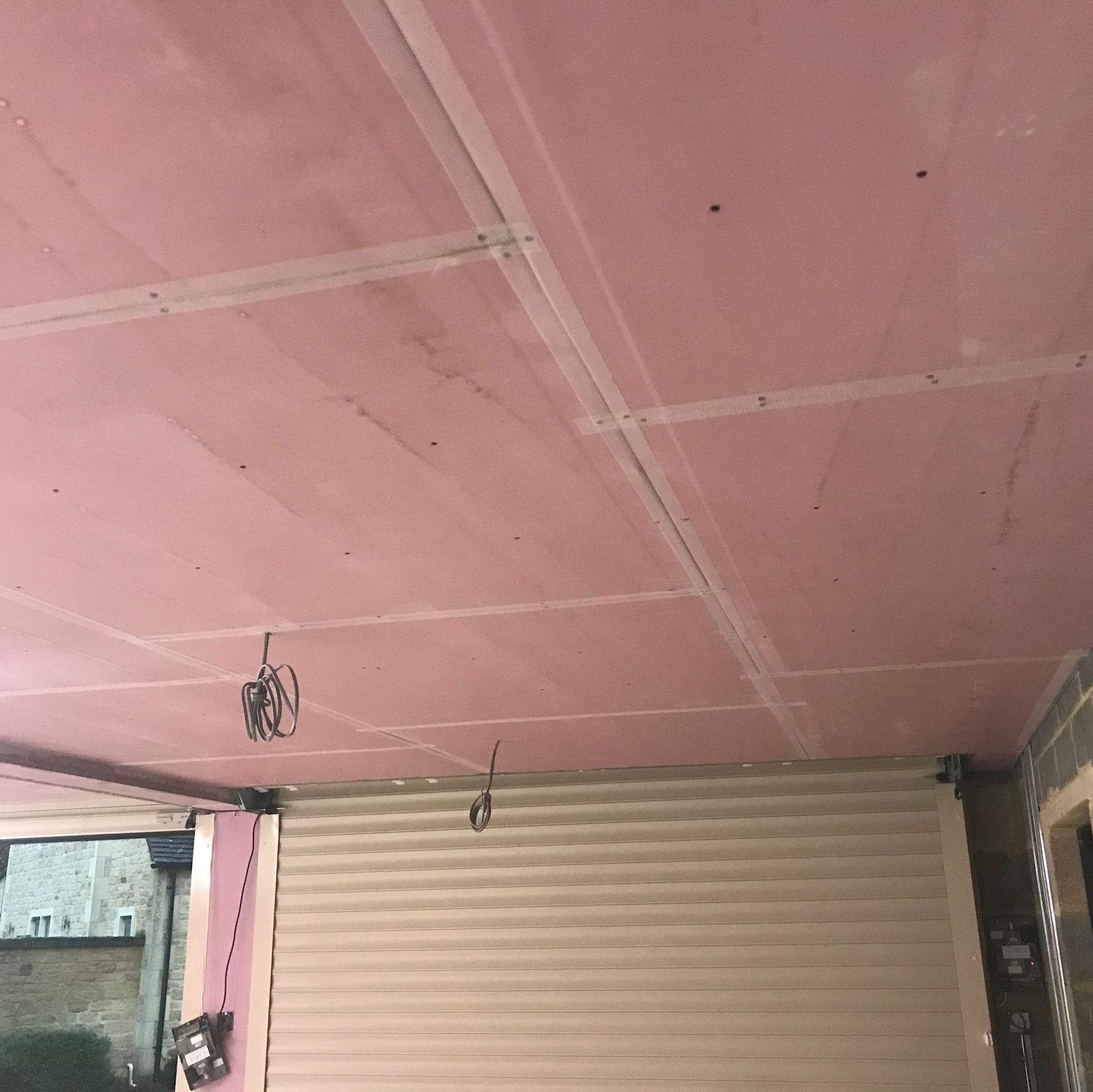 Pink Fireline plasterboard fixed to a ceiling