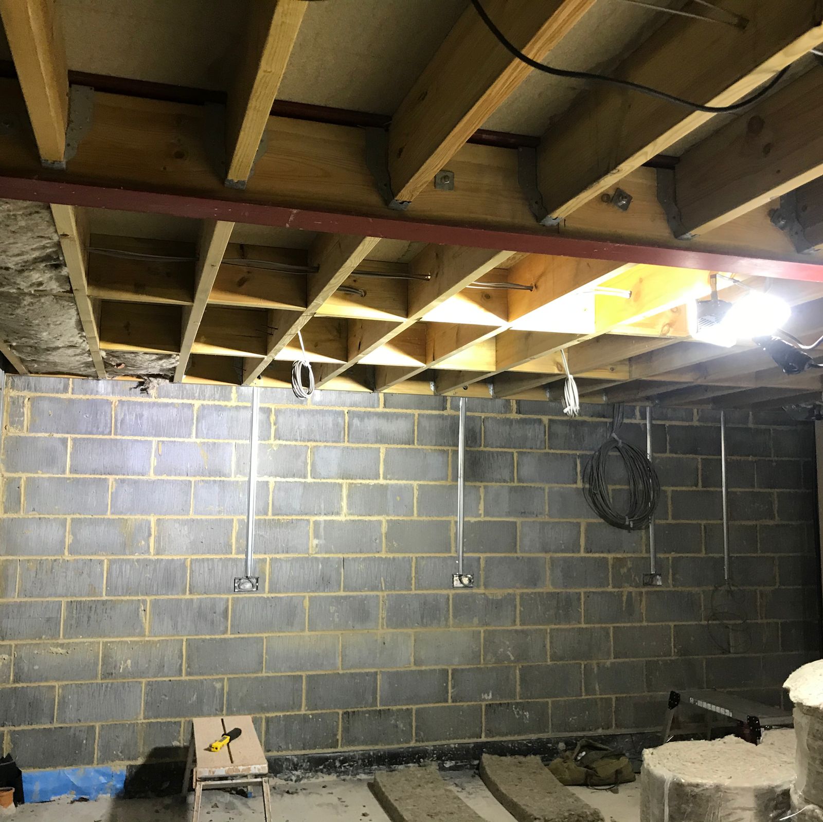 Sheep's wool insulation going in between timber joists above blockwork walls