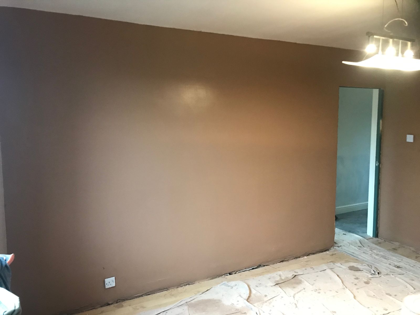 A living room wall re-skimmed and drying