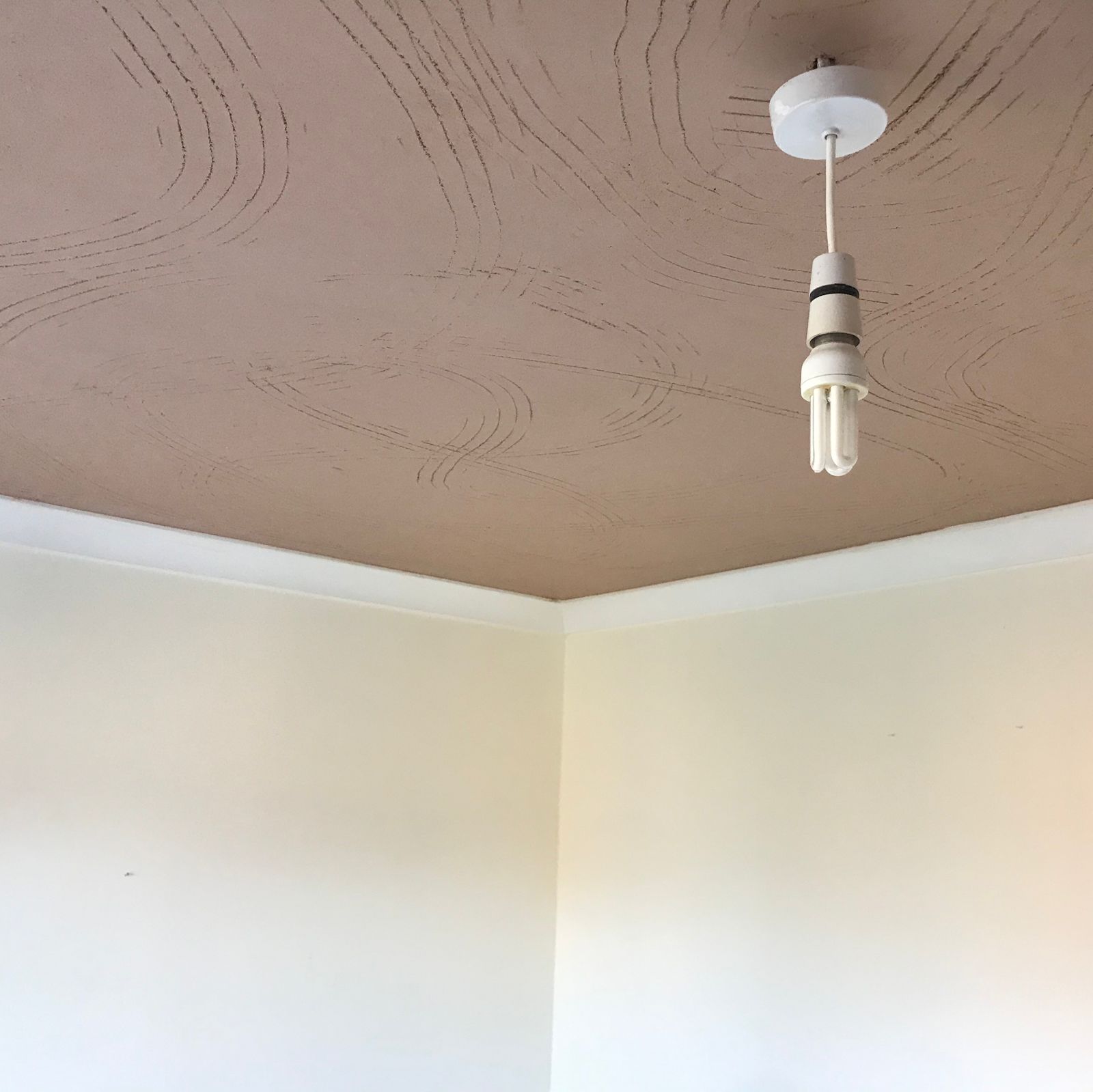 Artex coming off a ceiling above a pale painted room