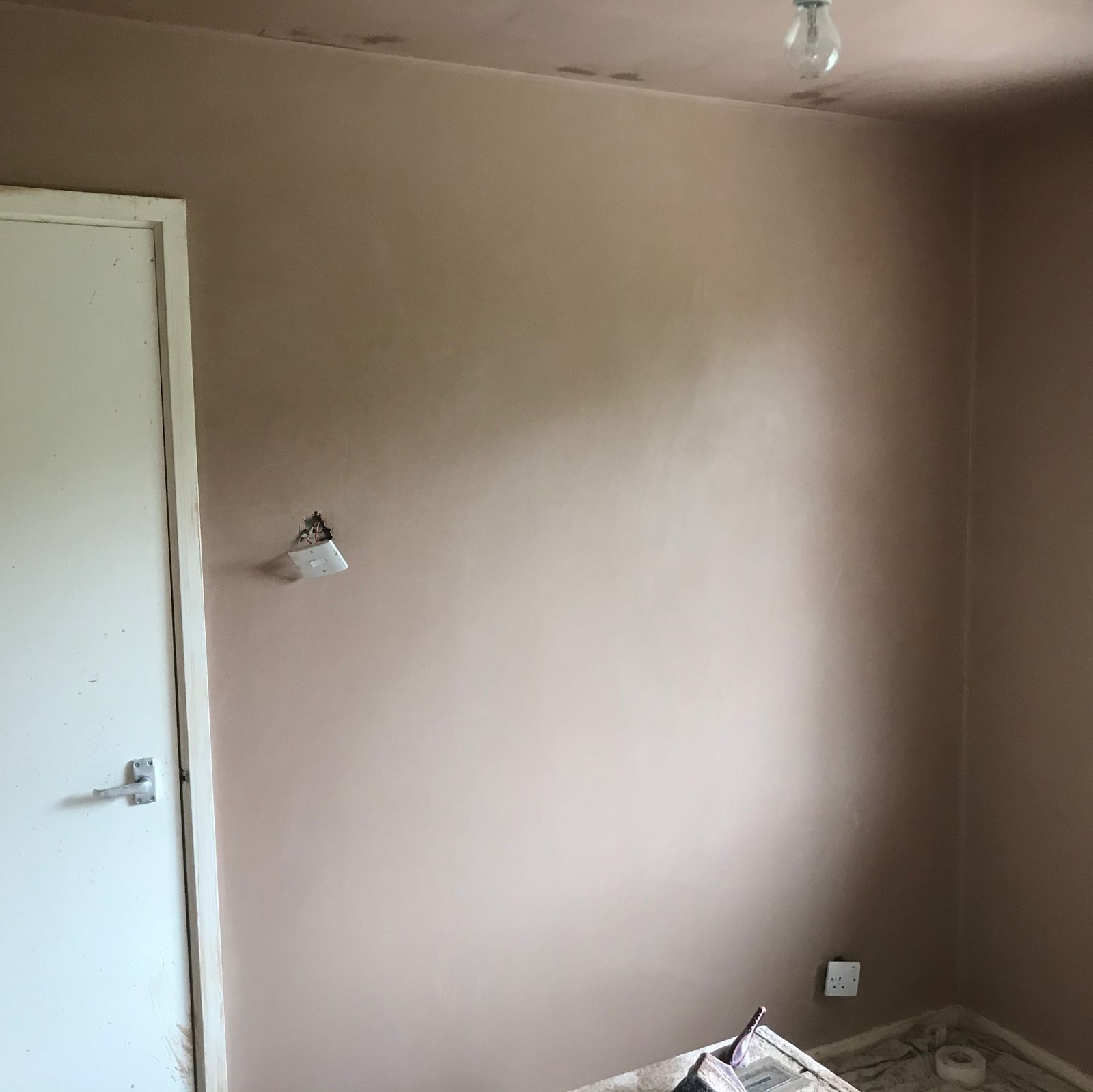 A freshly skimmed wall beside a white door