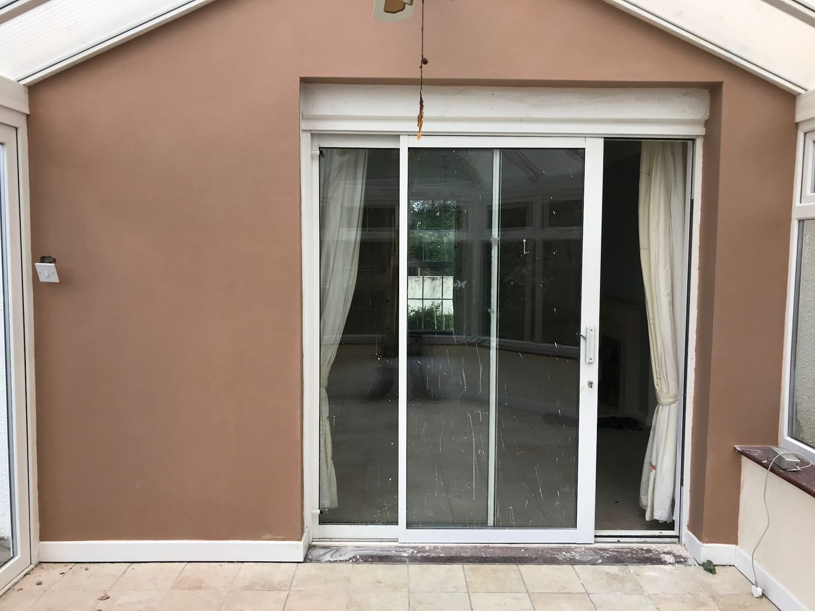 A plastered room with patio doors