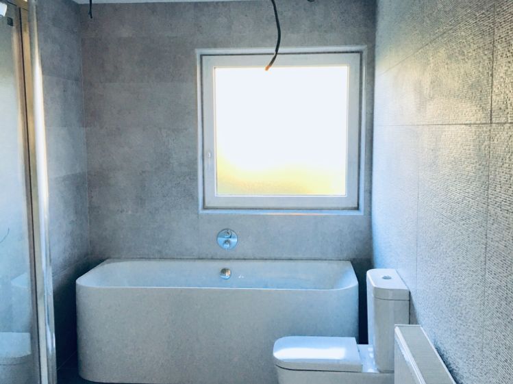 A new bathroom with a freestanding bath under a window