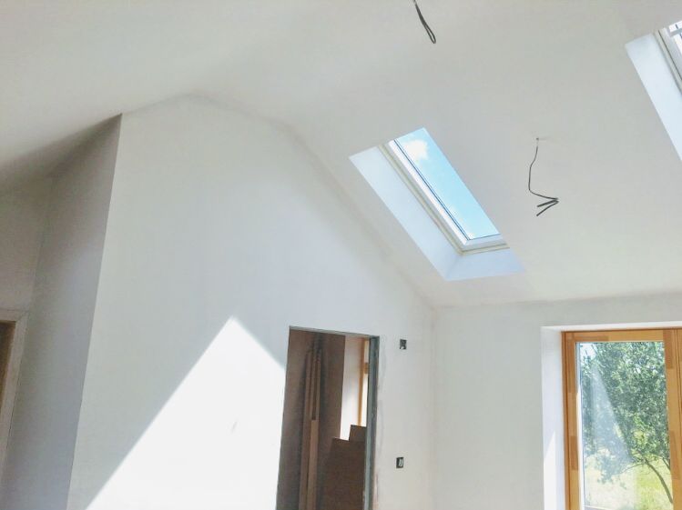 A painted room with roof windows and a sloping ceiling