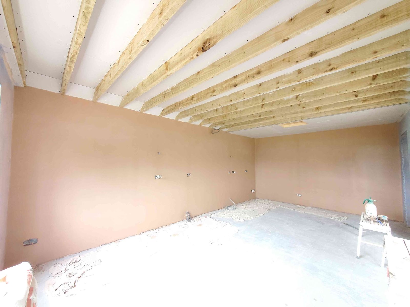 A long room freshly plastered under new ceiling joists